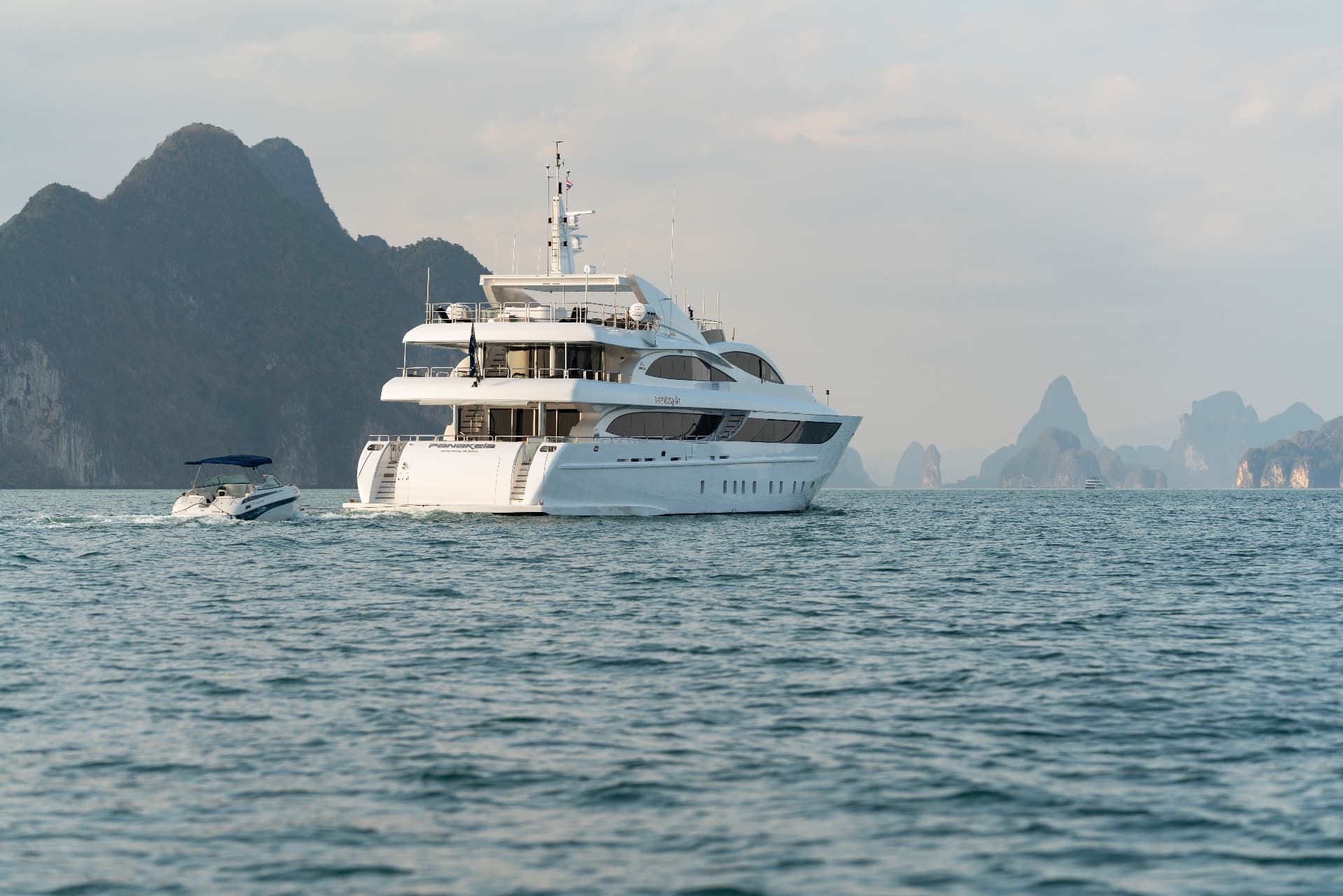 Phuket superyacht charter cruising past Krabi limestone cliffs at golden hour