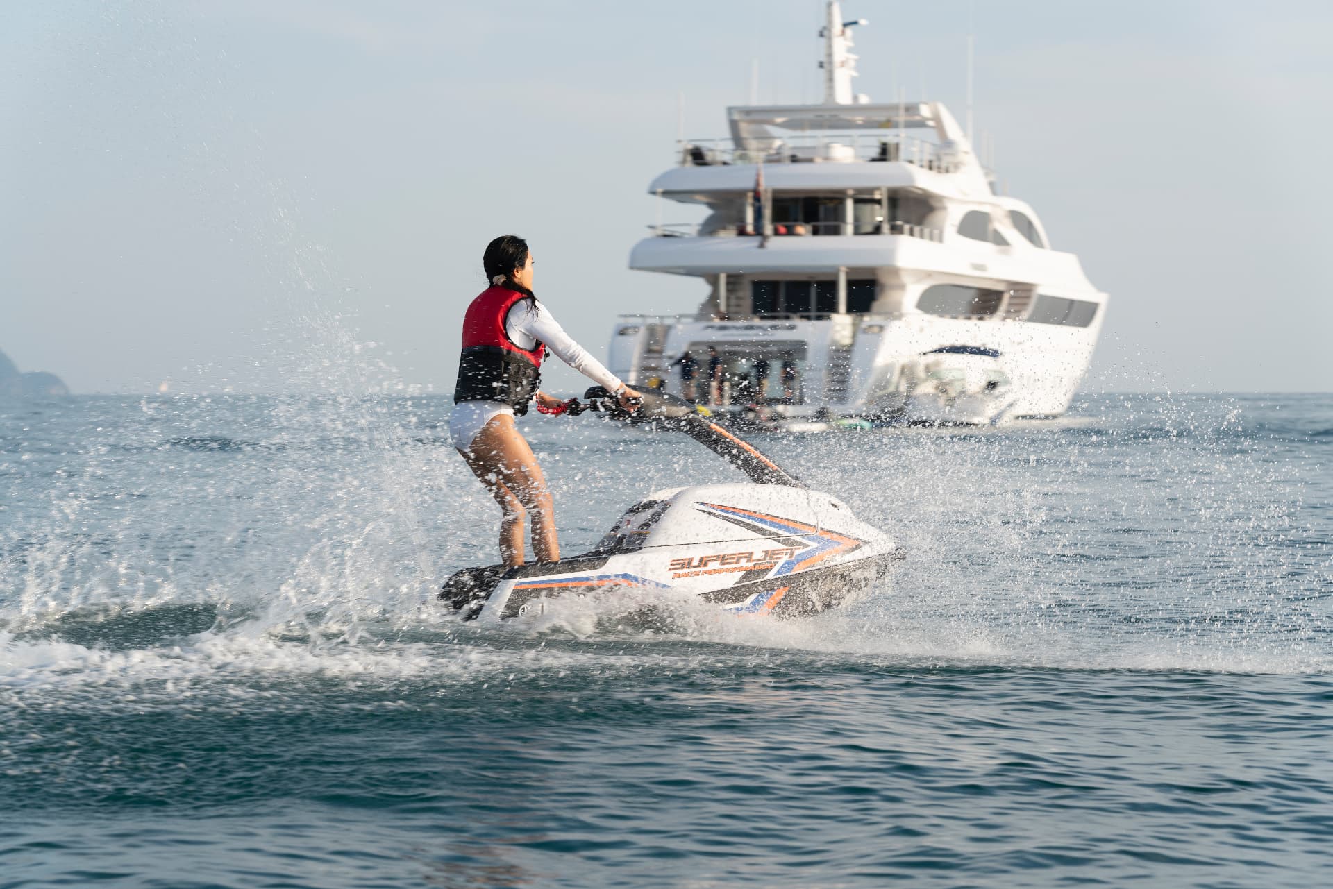 Guest riding a stand-up jet ski beside a Phuket superyacht charter